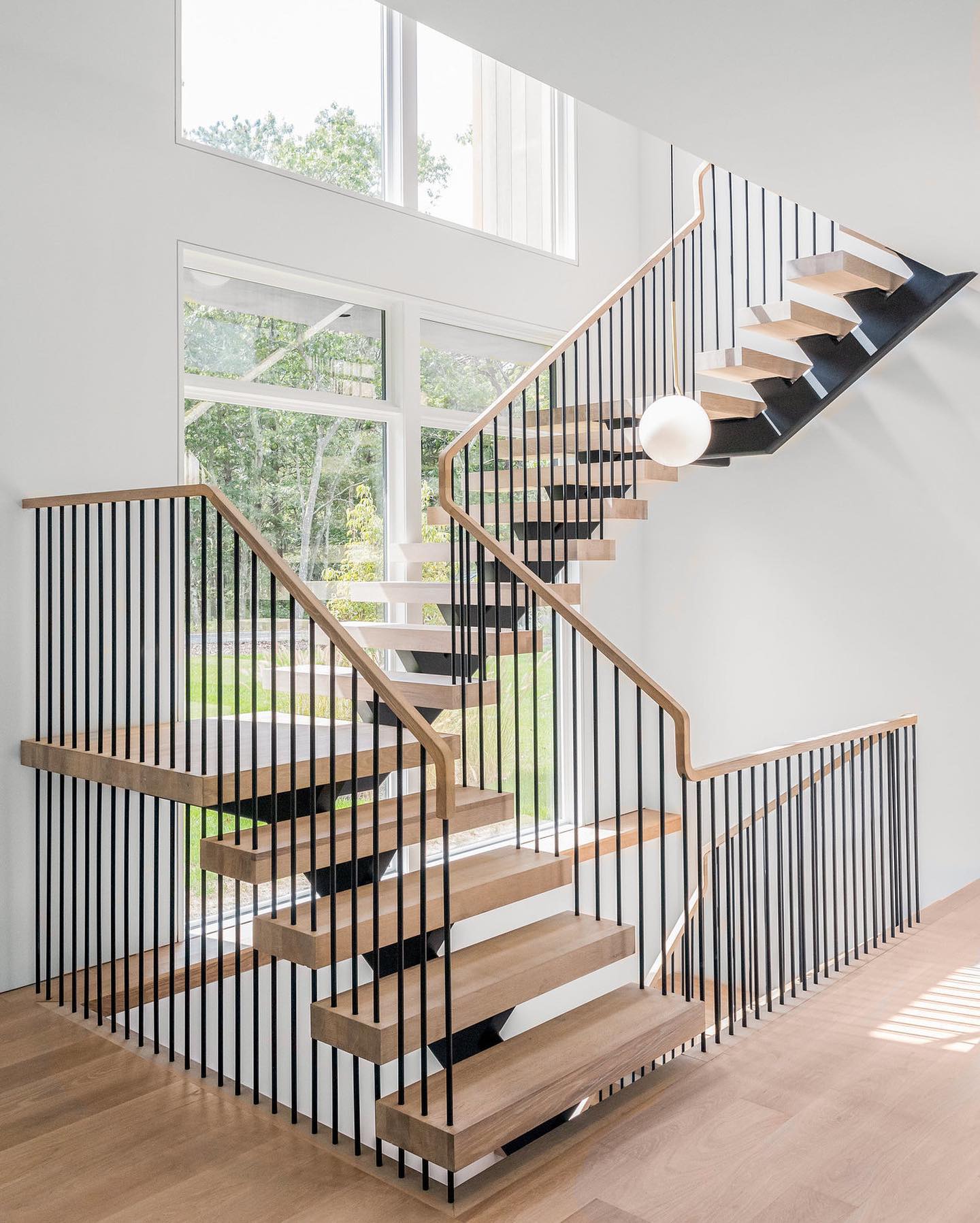 Modern straight staircase with metal railing and solid wood tread